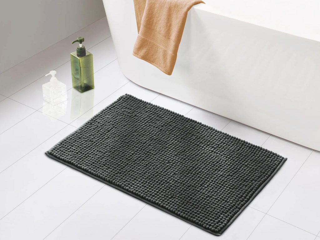 dark grey chenille bath rug in front of bath tub