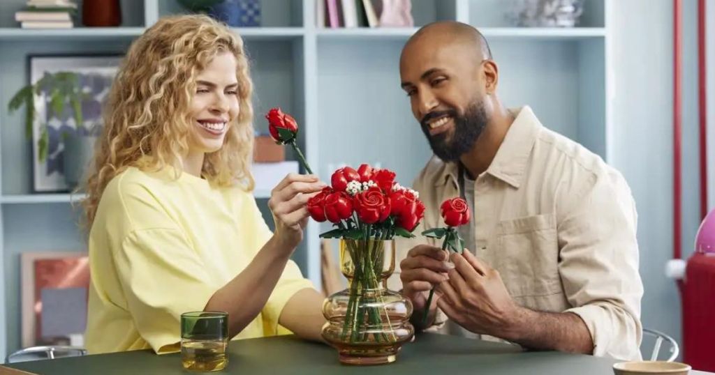 A woman and a man making the LEGO Bouquet of Roses floral arrangement