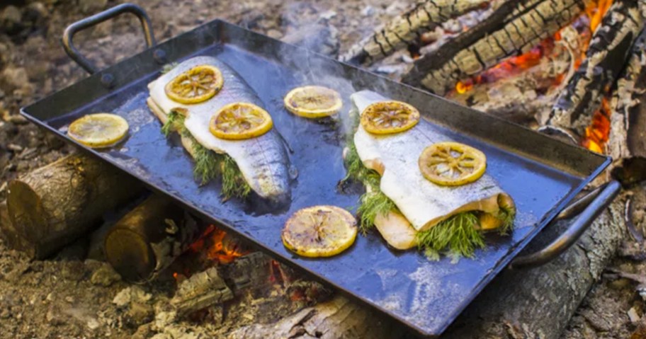 fish and lemon slices on lodge griddle over campfire