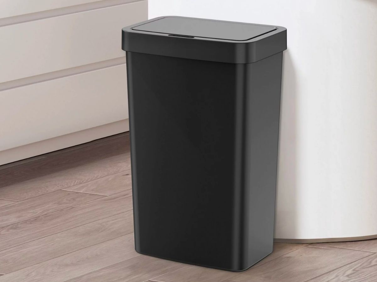 a black plastic 13 gallon trash can in a kitchen at the end of a bar counter