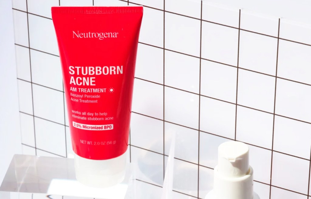 red bottle of Neutrogena Stubborn Acne AM Face Treatment in bathroom