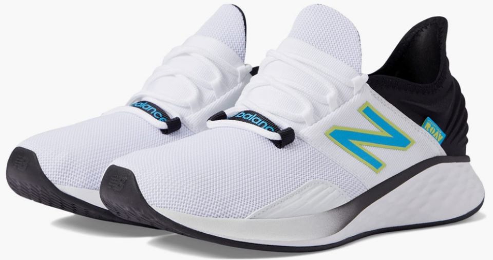 Pair of white New Balance sneakers with a blue logo and black backs