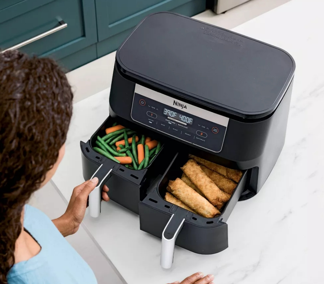 Woman opening the baskets on a Ninja air fryer