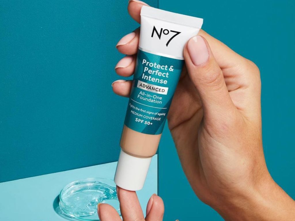 hands holding a tube of No7 Protect & Perfect Intense Foundation