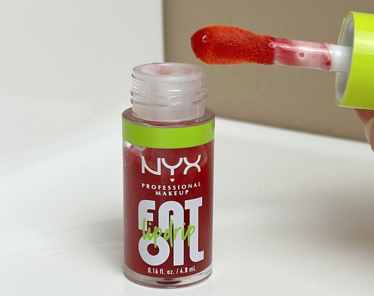 A bottle of fat oil lip drip shown with the applicator on a bathroom counter