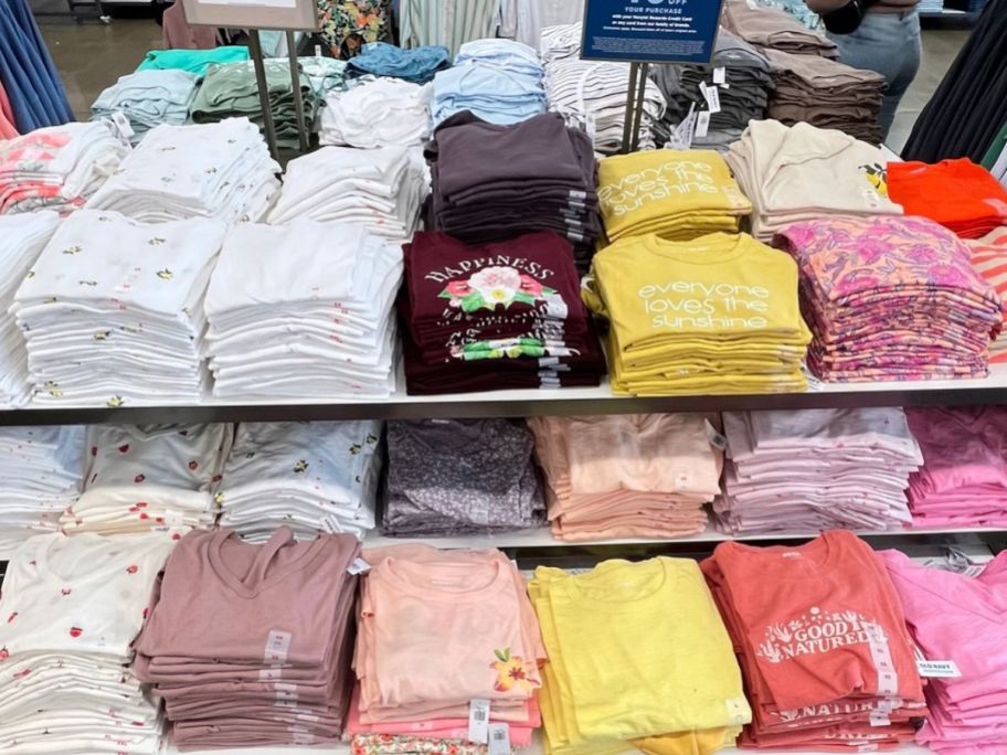 Table of women's graphic tees folded at Old Navy