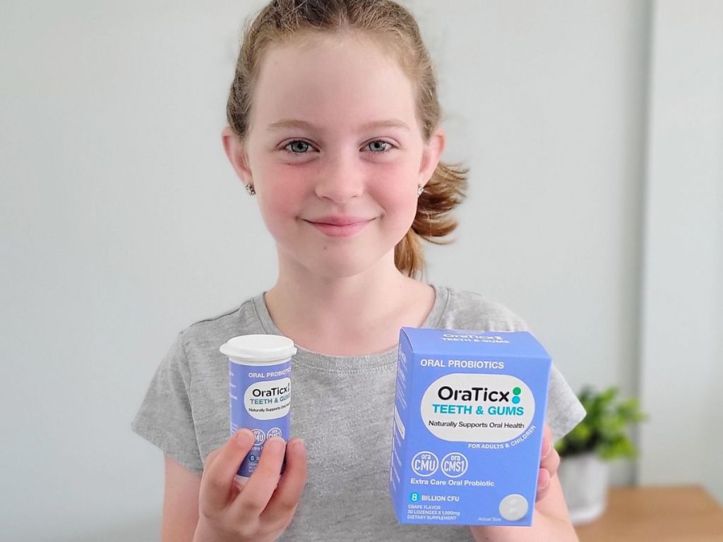 Little girl holding Oraticx probiotics