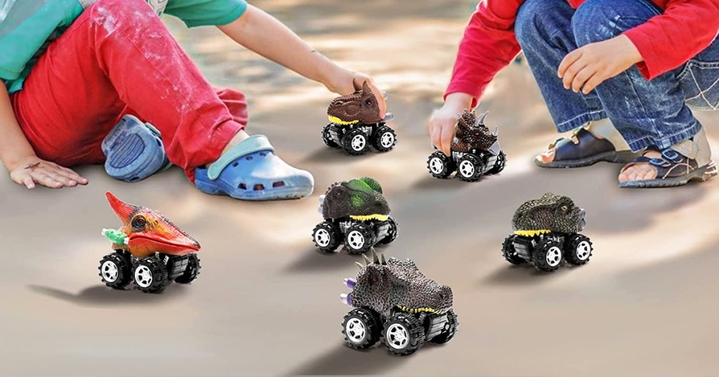two boys playing with mini dinosaur car toys