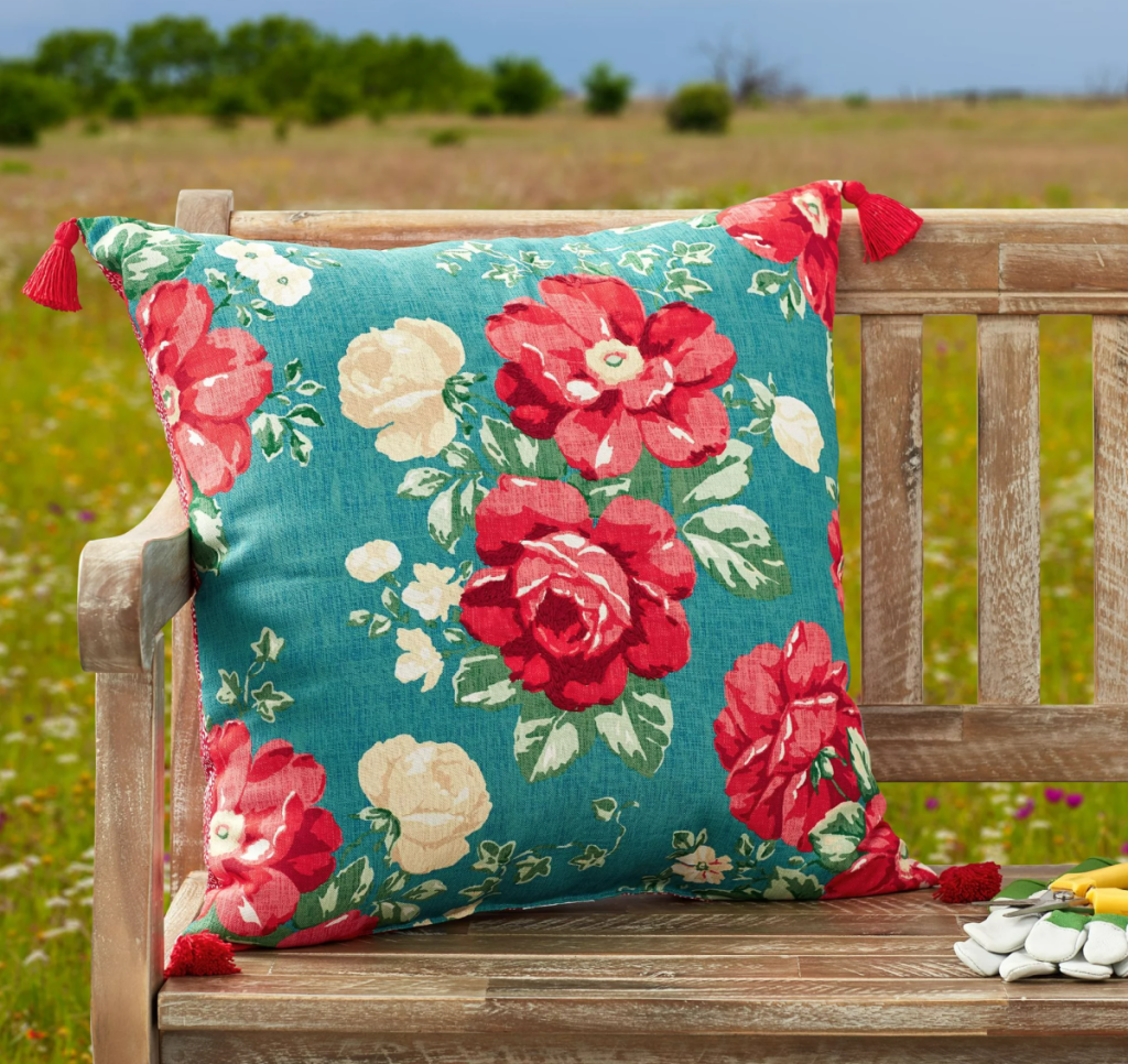 The Pioneer Woman Vintage Flower Pillow displayed on an outdoor bench