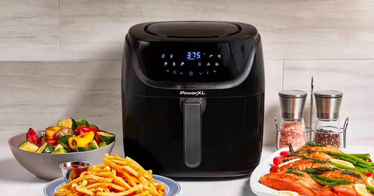 PowerXL Vortex Pro Air Fryer 8qt - Black on a kitchen counter surrounded by crisy delicious looking foods