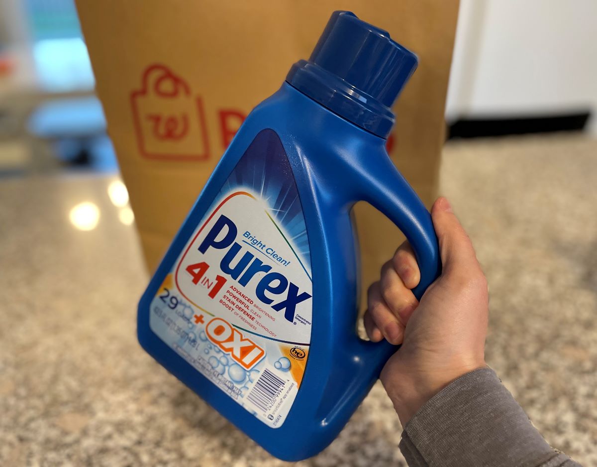 Hand holding a bottle of Purex Laundry Detergent