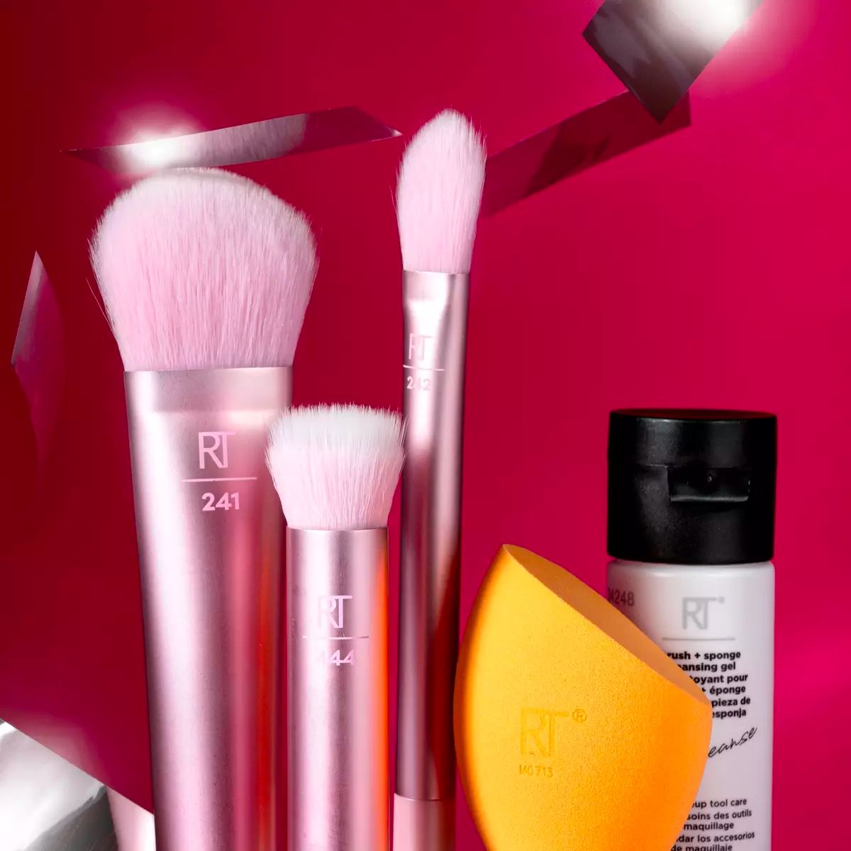 Real Techniques Feeling Festive 5-Piece Makeup Brush + Sponge Gift Set displayed on a dark pink background