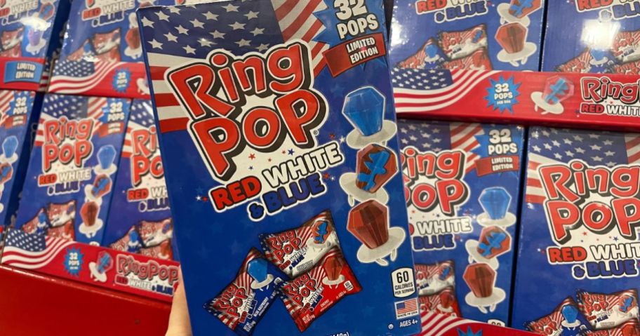 A hand holding a Ring Pop Red, White, and Blue Variety Pack 32-Count Box 