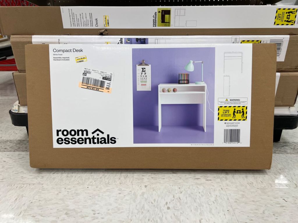 Box for a white desk sitting on the floor of a store