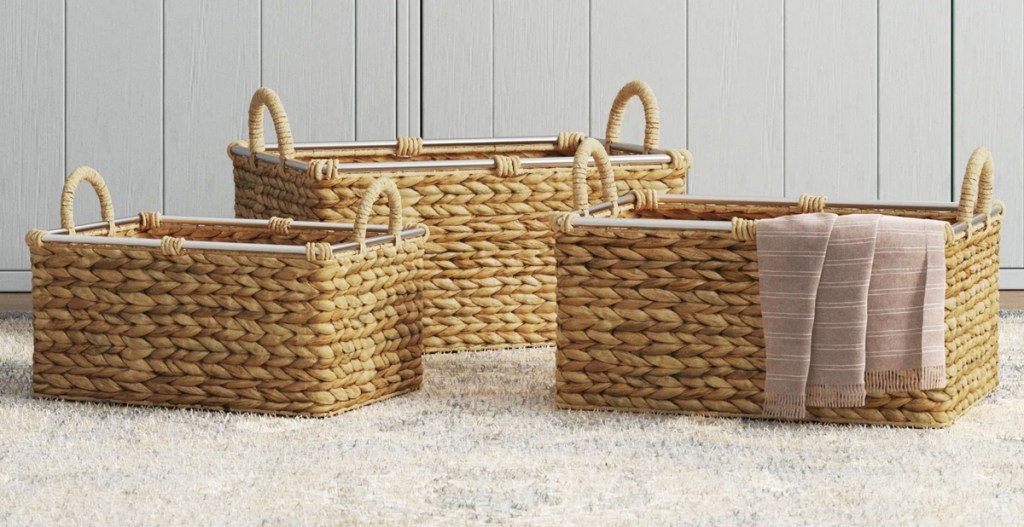 three seagrass baskets sitting on the floor