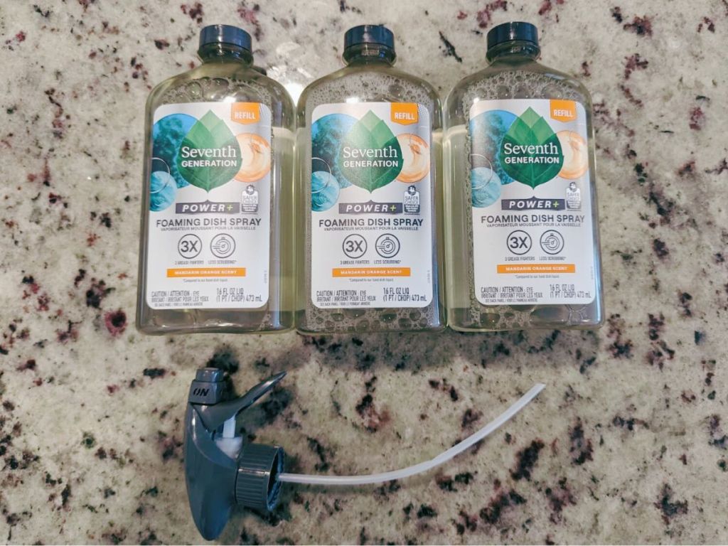 3 bottles of Seventh Gen foaming dish spray with sprayer on marble surface