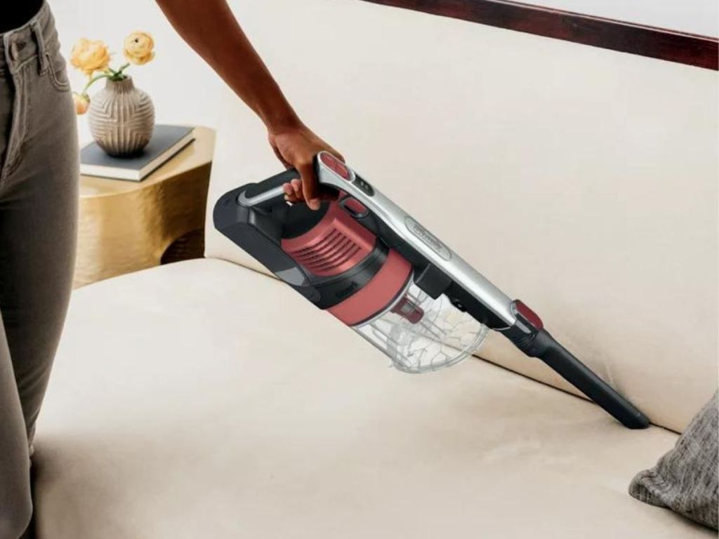 person using vacuum attachment on couch
