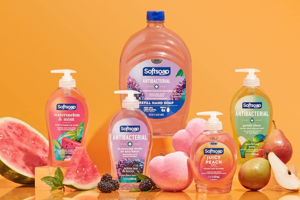 Four bottles of Softsoap hand soap with a large refill bottle behind them