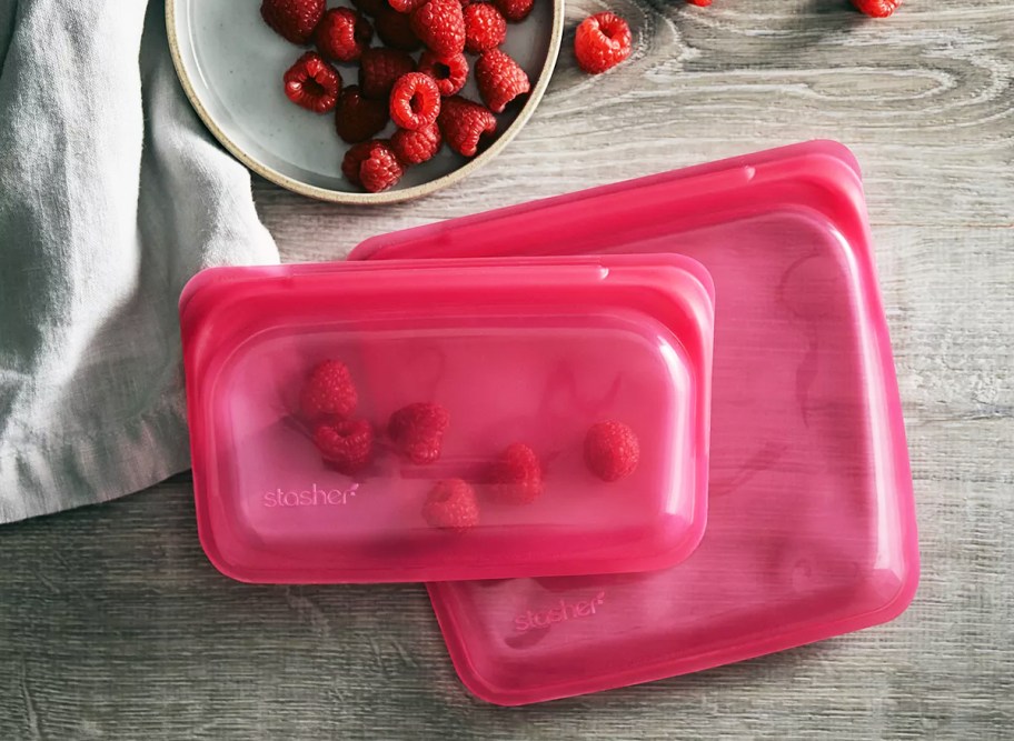 pink stasher sandwich and snack bags laying on counter near raspberries