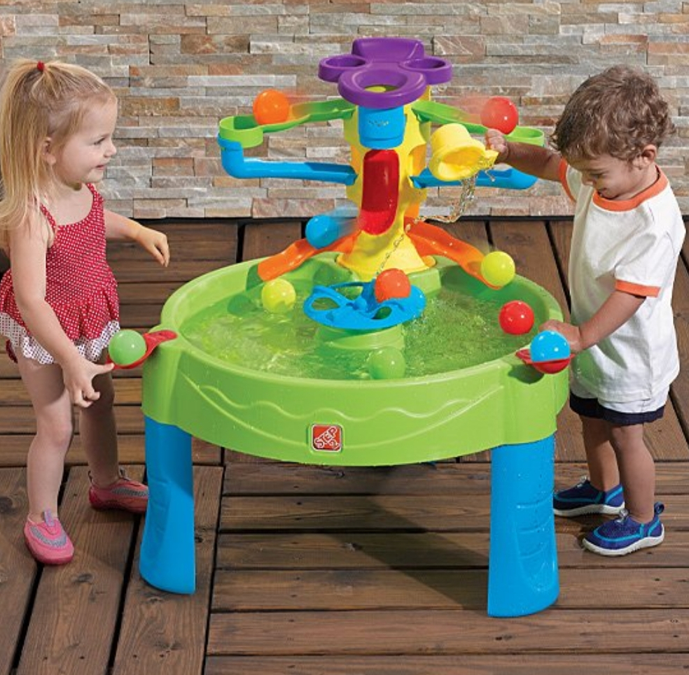 Kids playing with a table with toy balls