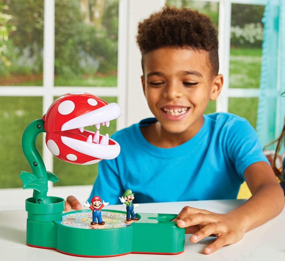 A boy playing a tabletop Super Mario game called Piranha Plant Escape