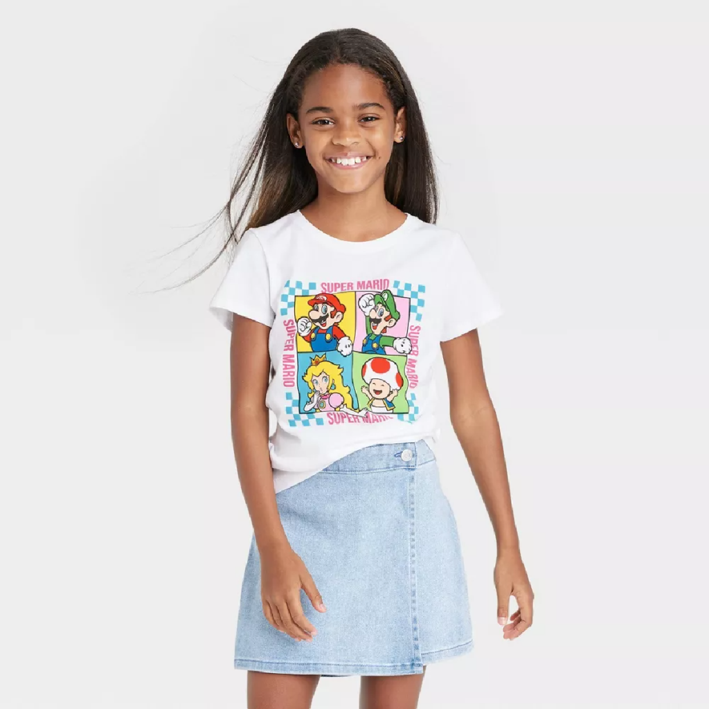 A gamer girl wearing a super mario shirt depicting mario, luigi, peach, and toad