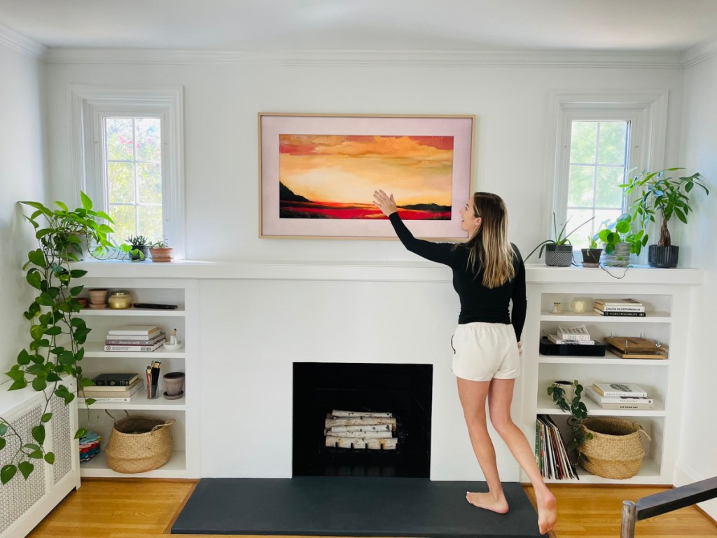 woman using Frame TV over fireplace