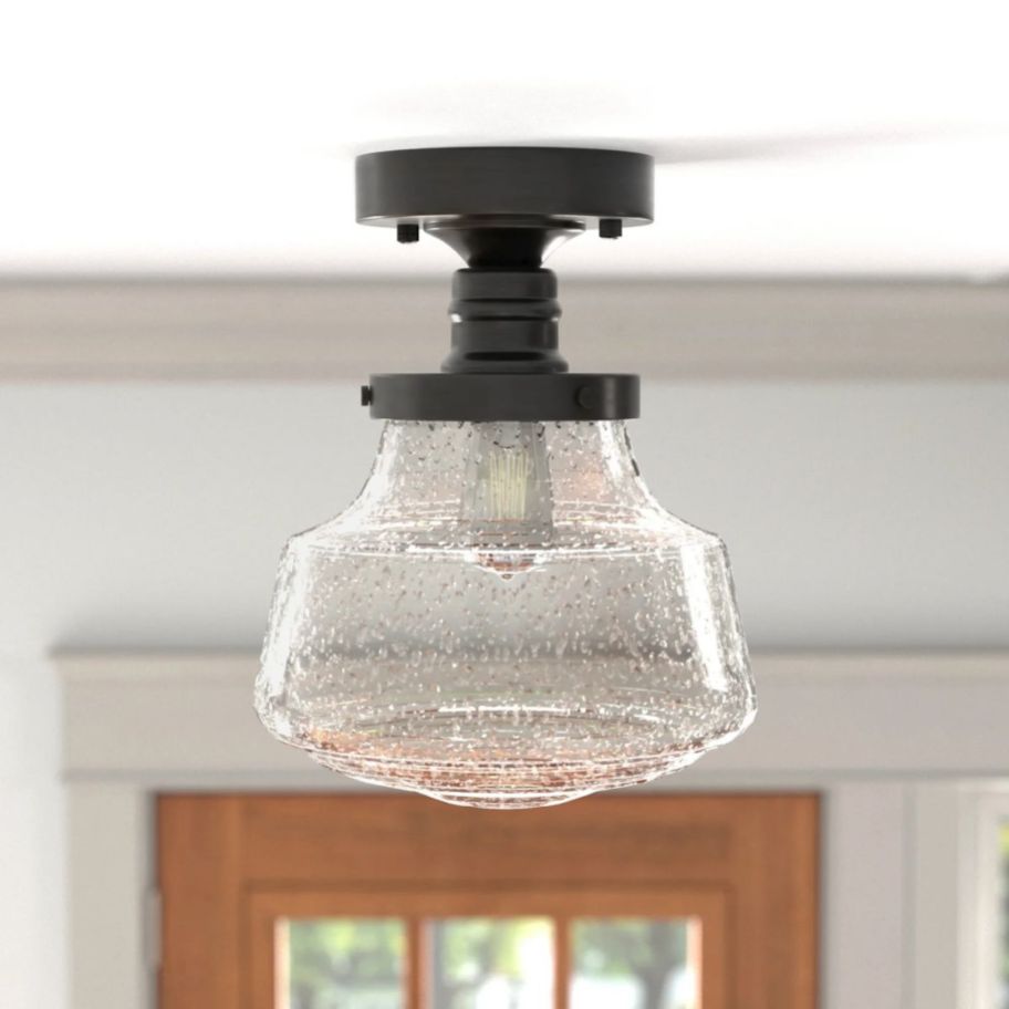 a semi flush mount light fixture with a bubble glass globe