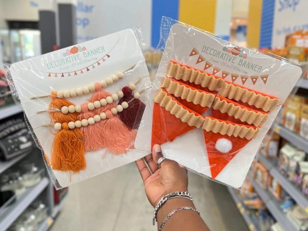 hand holding up two packs of fall garland from Walmart
