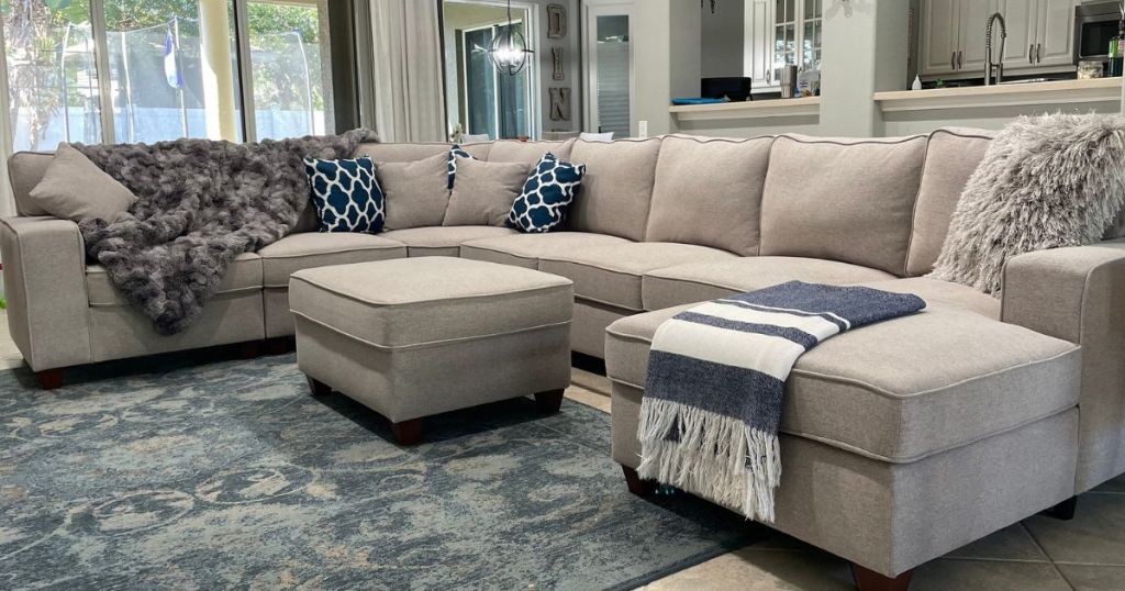 Sectional couch in living room with throws and pillows on it