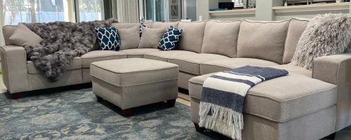 Sectional couch in living room with throws and pillows on it