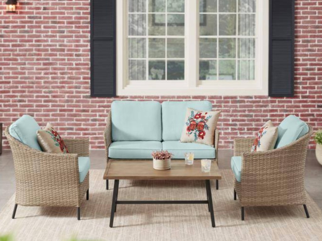 4-piece wicker patio set outside on top of area rug
