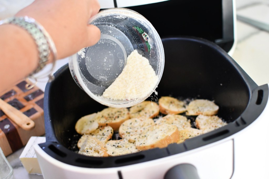 adding parmesan cheese to homemade bagel chips