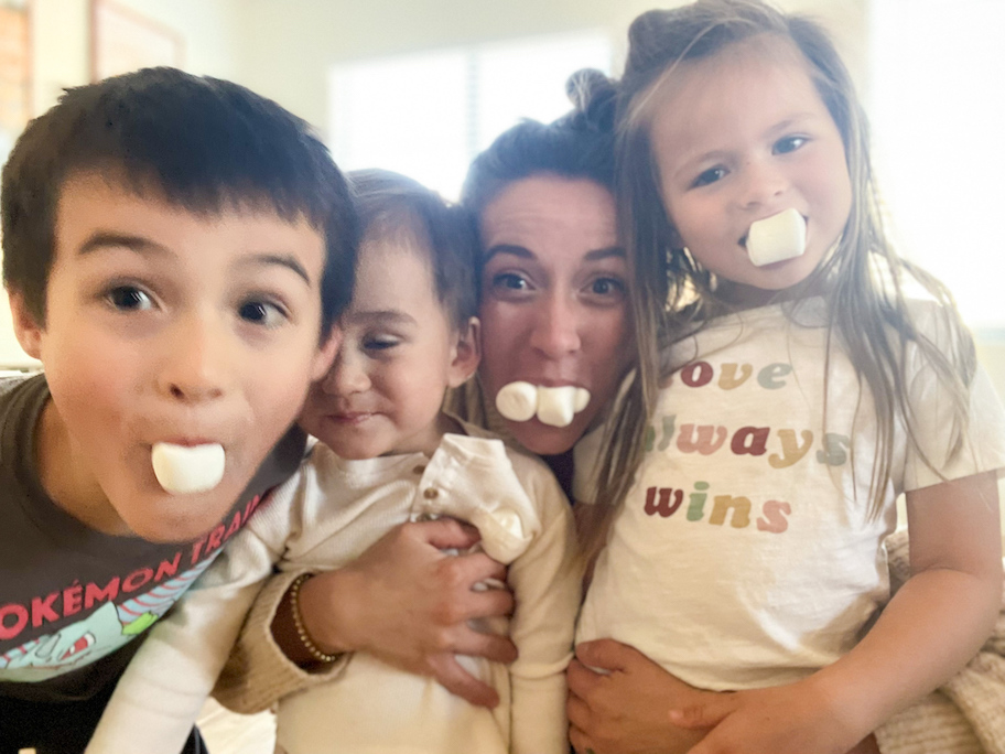 woman with kids with marshmallows in mouth 