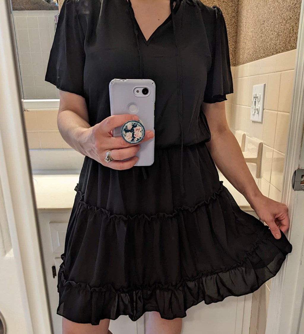 woman taking mirror selfie wearing black dress