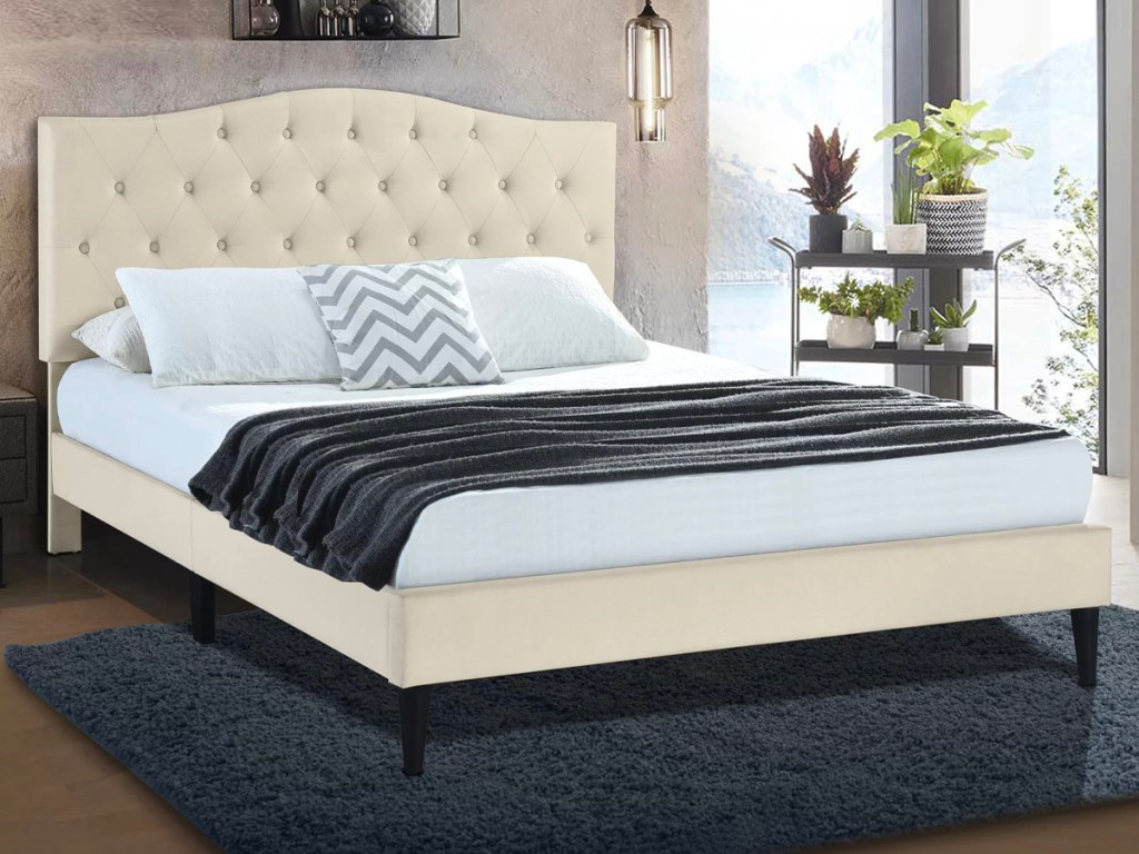 beige bedframe and headboard with white and black comforter