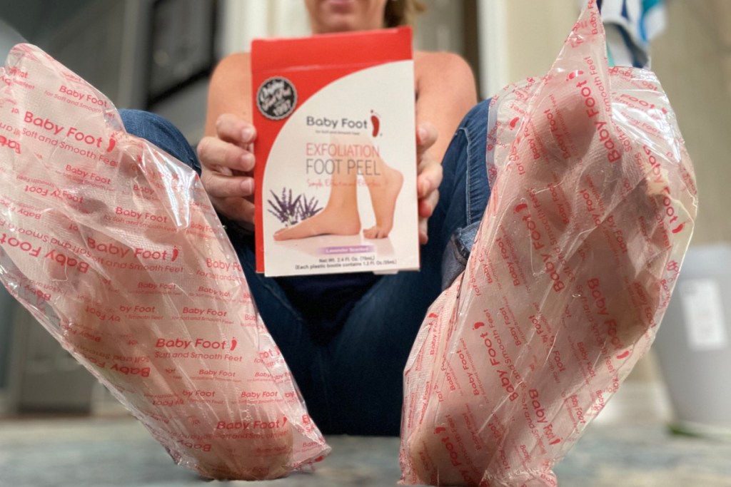 woman holding foot peel box with wraps on feet