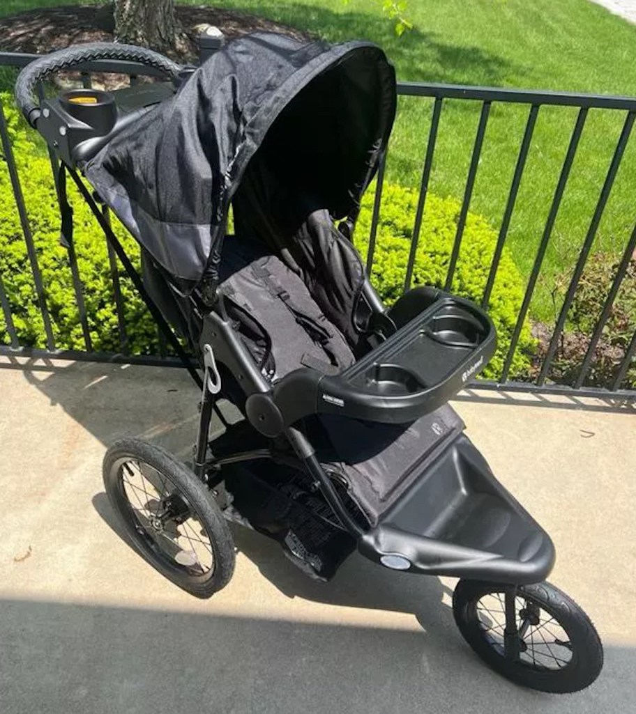 baby trend jogging stroller in black sitting on sidewalk