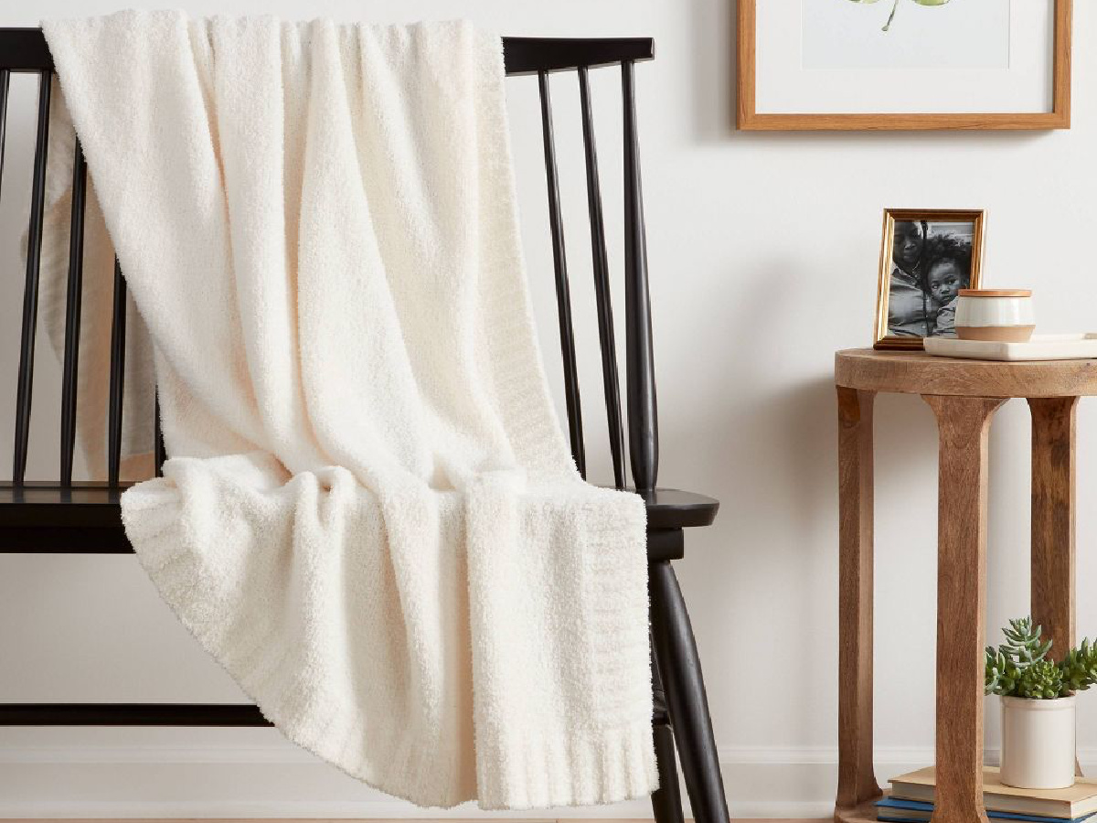white throw blanket on chair that is placed in living space.