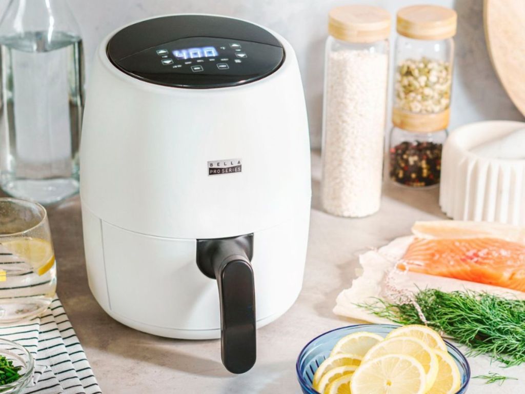 matte white Bella air fryer on table surrounded by bowl of lemonds and fresh fish