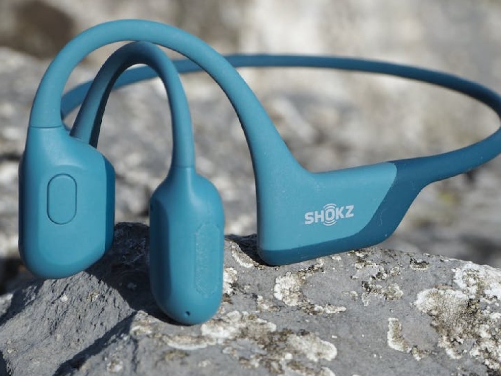 blue shokz headphones displayed on a rock