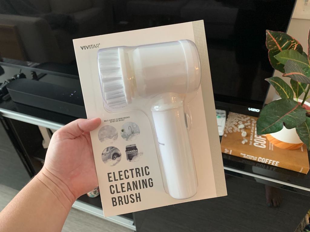 hand holding an electric cleaning brush in package