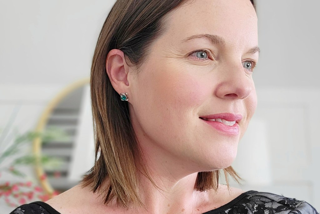 woman wearing green birthstone flower stud earrings