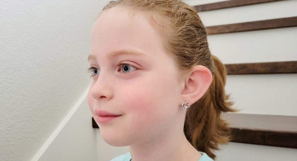 little girl wearing flower stud earrings