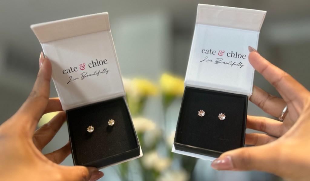 hands holding two stud earring boxes