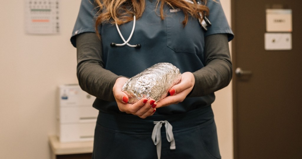nurse holding a foil-wrapped burrito