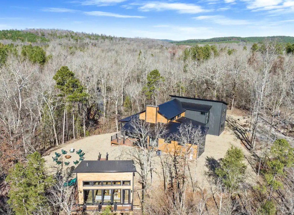 drone view of huge modern house and treehouse in woods
