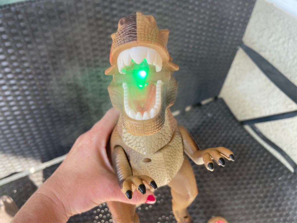dino toy with green light in mouth showing mist