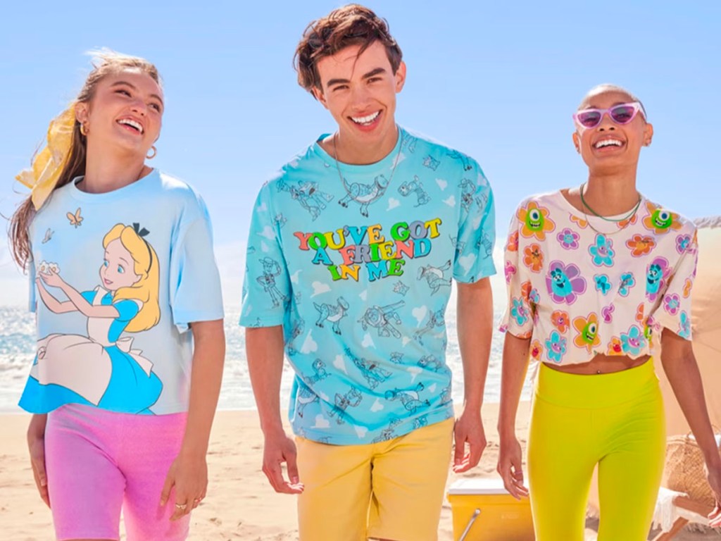 two women and one man wearing disney tees at beach