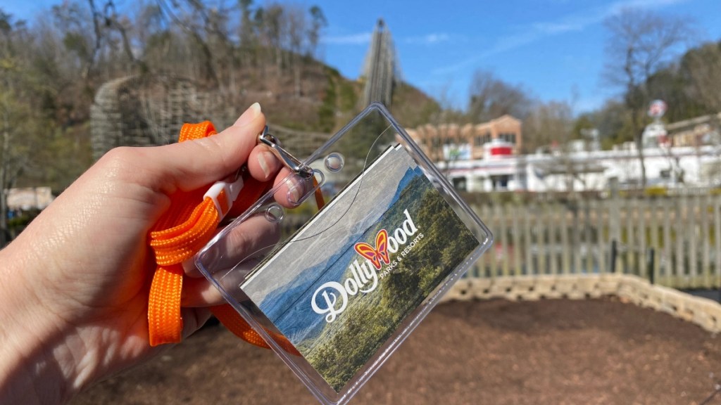 holding a Dollywood season pass on an orange lanyard